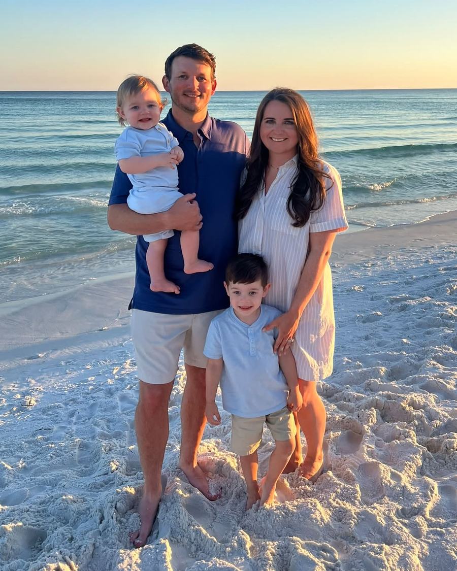 Mike Adcock with his family on the beach at sunset.